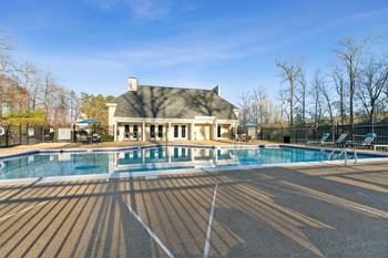 A swimming pool with a house in the background